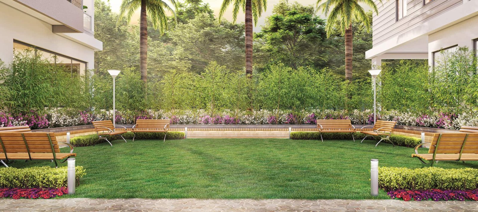 Central lawn ringed with benches, flower beds and palms at Lal Chand Eco Heights