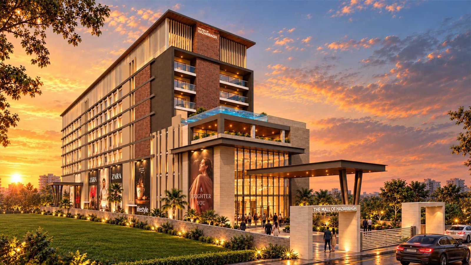 Front elevation of The Mall of Hazaribagh with a glazed entrance, landscaped lawn and illuminated gateway at sunset